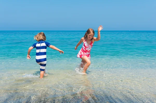 Two kids having fun on summer vacation, playing in the sea, image taken in Tropea, Calabria, Italy — Stock Photo, Image