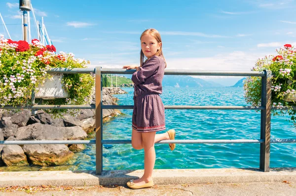 Nettes kleines Mädchen von 7-8 Jahren, das sich an einem schönen Sommertag am See ausruht — Stockfoto