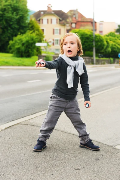 Retrato ao ar livre de um menino de moda bonito na rua, vestindo, roupas cinza e sapatos azuis escuros — Fotografia de Stock
