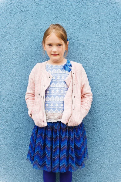 Outdoor portrait of a cute little fashion girl, wearing pink jacket and blue skirt — Stok fotoğraf