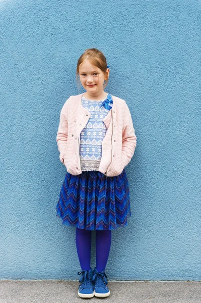 Outdoor portrait of a cute little fashion girl, wearing pink jacket and blue skirt — Stock Photo, Image