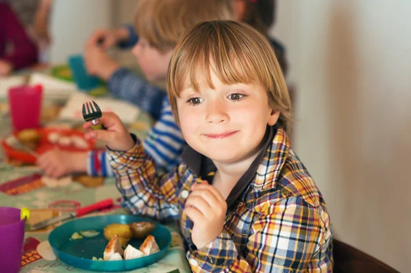 Adorable little boy having lunch with his friends — Stock Photo, Image