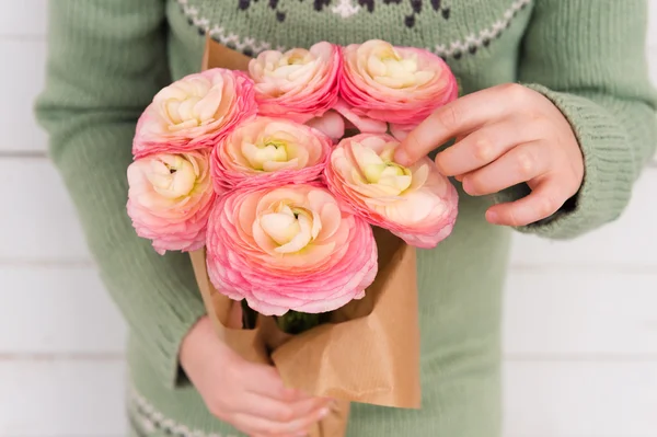 Hermoso ramo de ranúnculo rosa suave en las manos del niño, concepto del día de la madre — Foto de Stock