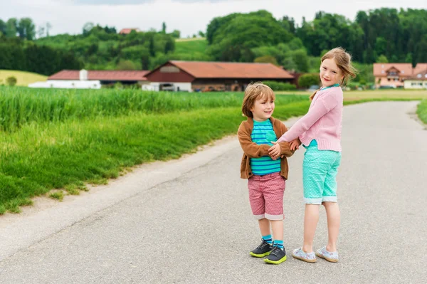 Dvě roztomilé děti hrají v krajině — Stock fotografie