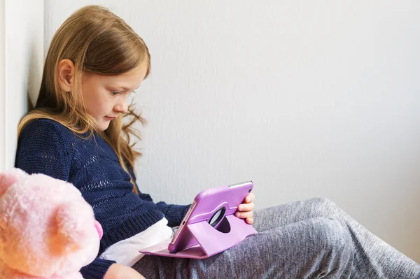 Adorabile bambina che gioca su un tablet digitale — Foto Stock