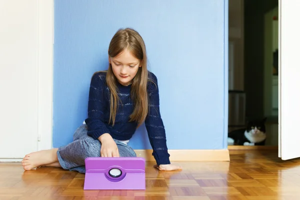 Adorable petite fille jouant sur une tablette numérique — Photo