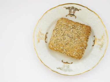 Beyaz arka planda porselen kaplama üzerinde ayçiçeği çöreği, fotoğraf