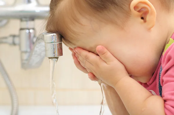 Meisje haar gezicht wassen — Stockfoto