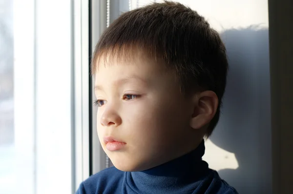 Boy sitting on the window with sadness — Stock Photo, Image