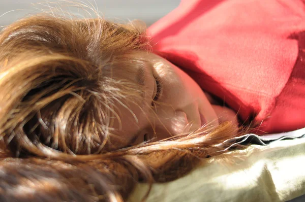 Woman lying with shining hair on sunshine — Stock Photo, Image