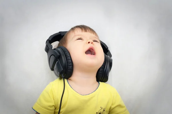 Petite fille avec casque chantant chanson — Photo