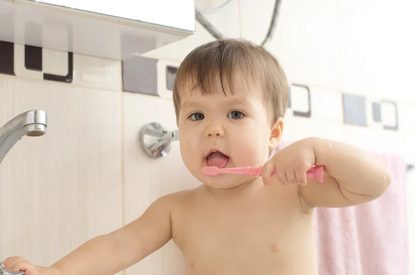 Barn rengöring tänder i badrum — Stockfoto