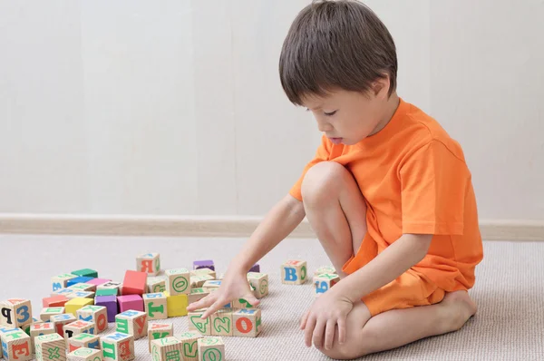 Niño jugando con cubos de juguete — Foto de Stock