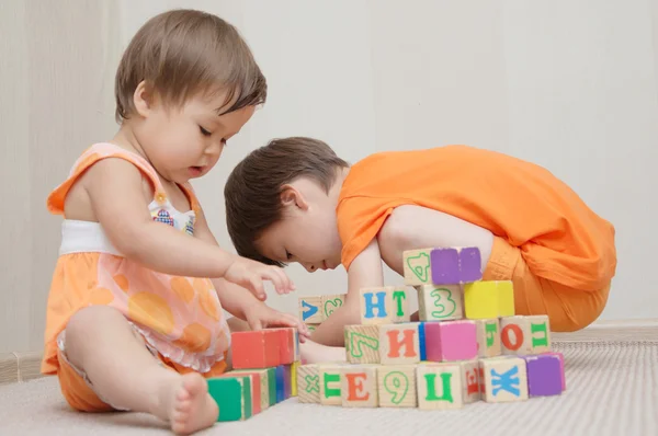 Hermano y hermana jugando con cubos de juguete — Foto de Stock