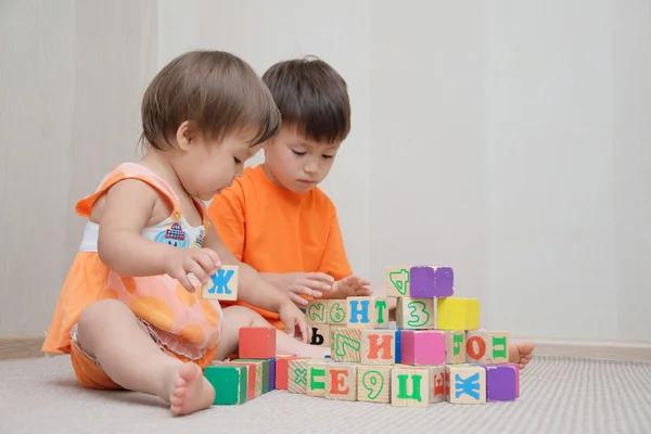 Hermano y hermanita construyendo con cubos de juguete — Foto de Stock