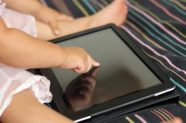 Bebé linda mano utilizando la tableta de pantalla táctil PC — Foto de Stock