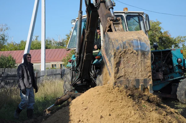 拖拉机用铲子挖一个洞 — 图库照片