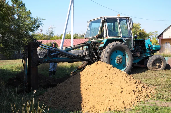 Trekker graven van een gat — Stockfoto