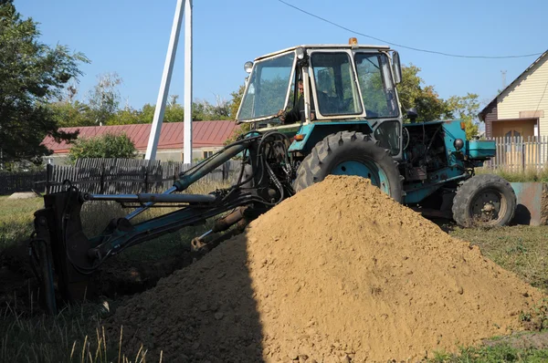 Trekker graven van een gat shoveling de grond — Stockfoto