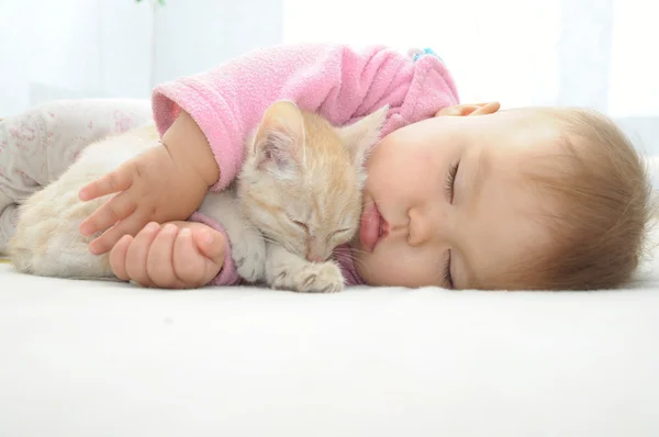 Bebê e gato dormindo juntos — Fotografia de Stock