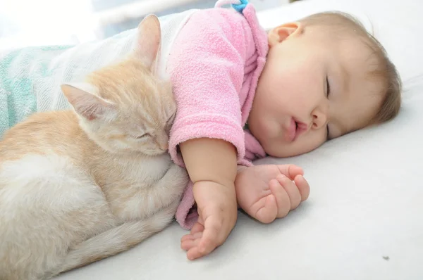 Bébé et chat couchent ensemble — Photo