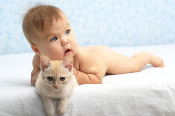 Bebé atrapado el gato acostado en la cama — Foto de Stock