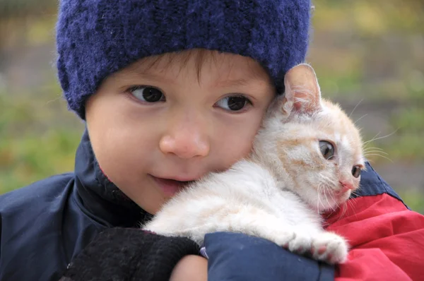 Niño sonriendo abrazando gato — Foto de Stock