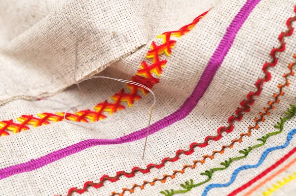 Needle on fabric with embroidery — Stock Photo, Image