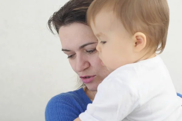 Barn med mor i mammas famn — Stockfoto