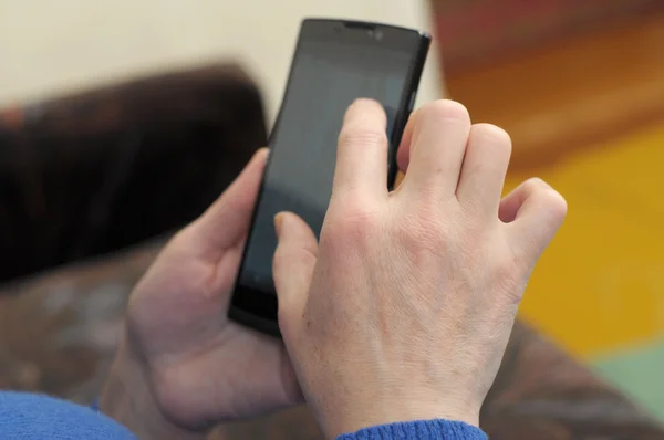 Mano de mujer usando un teléfono inteligente — Foto de Stock