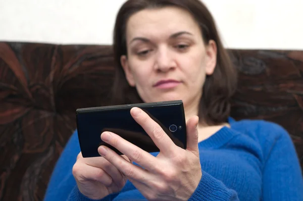 Mujer sosteniendo el teléfono celular, se centran en el teléfono — Foto de Stock