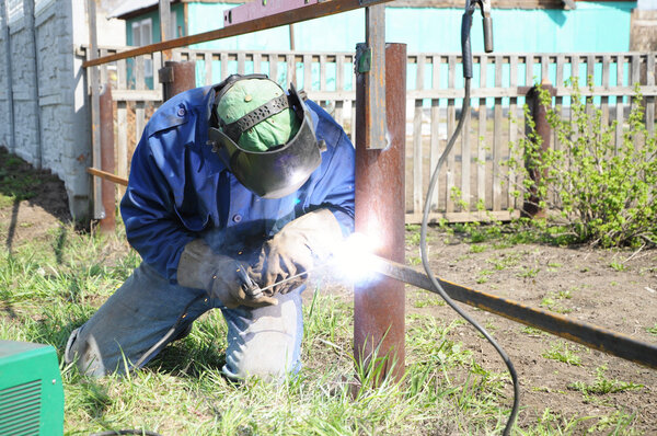 welder working and soldering iron with mask