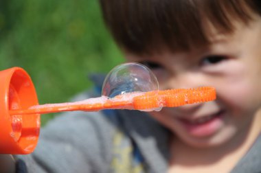 Kabarcık sopa üzerinde tutan çocuk