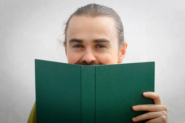 Man die lacht achter het boek — Stockfoto