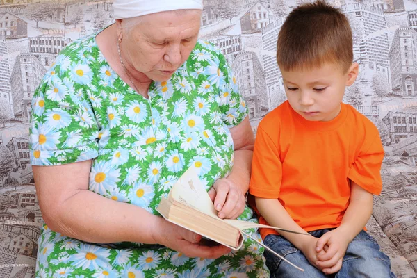 Бабушка читает внуку книжку — стоковое фото