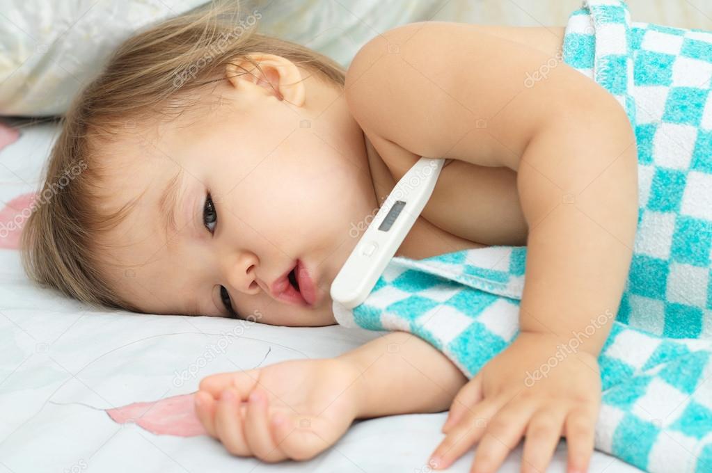 Baby ailing and lying with thermometer