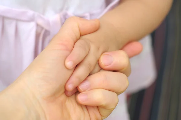 Pequena menina mãos em mães mãos — Fotografia de Stock
