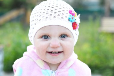 Beyaz örgü şapkalı portre gülümseyen şirin bebek