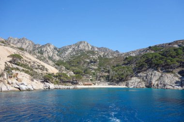 İtalya 'nın Portoferraio kentindeki Toskana Takımadası' nın Tyrhenian Denizi kıyısındaki Montecristo Adası 'ndaki Cala Maestra plajı.