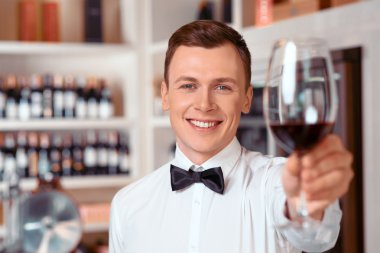Yakışıklı şarap bir bardak tutan yakışıklı sommelier