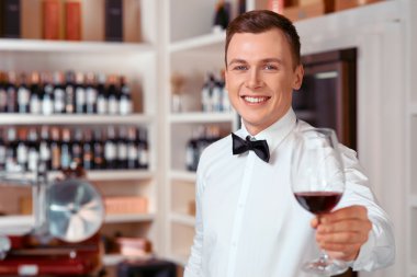 Yakışıklı şarap bir bardak tutan yakışıklı sommelier