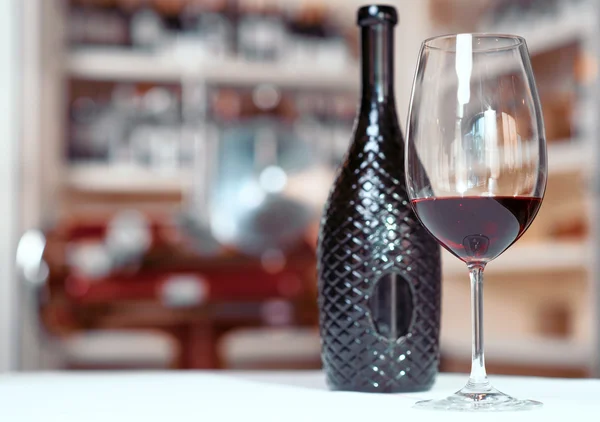 Cam ile masada duran şarap şişesi — Stok fotoğraf