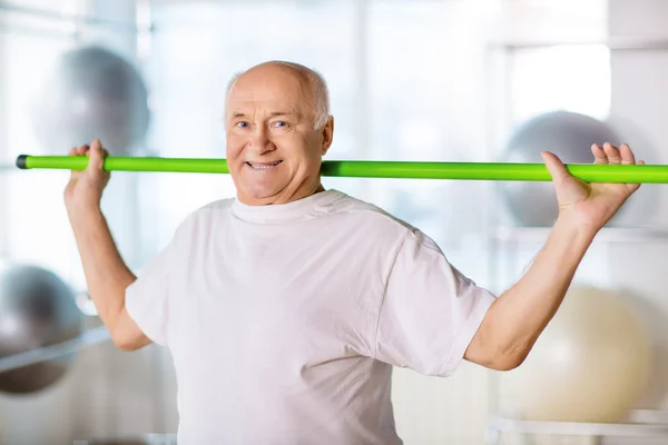 Starší muž držící sportovní hůl — Stock fotografie