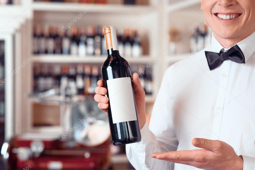 Professional sommelier holding wine bottle
