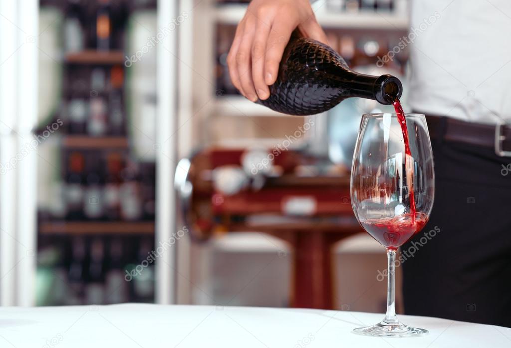 Sommelier pouring wine into wineglasses