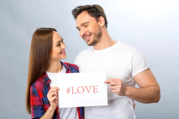 Nice young couple holding shit of paper — Stock Photo, Image