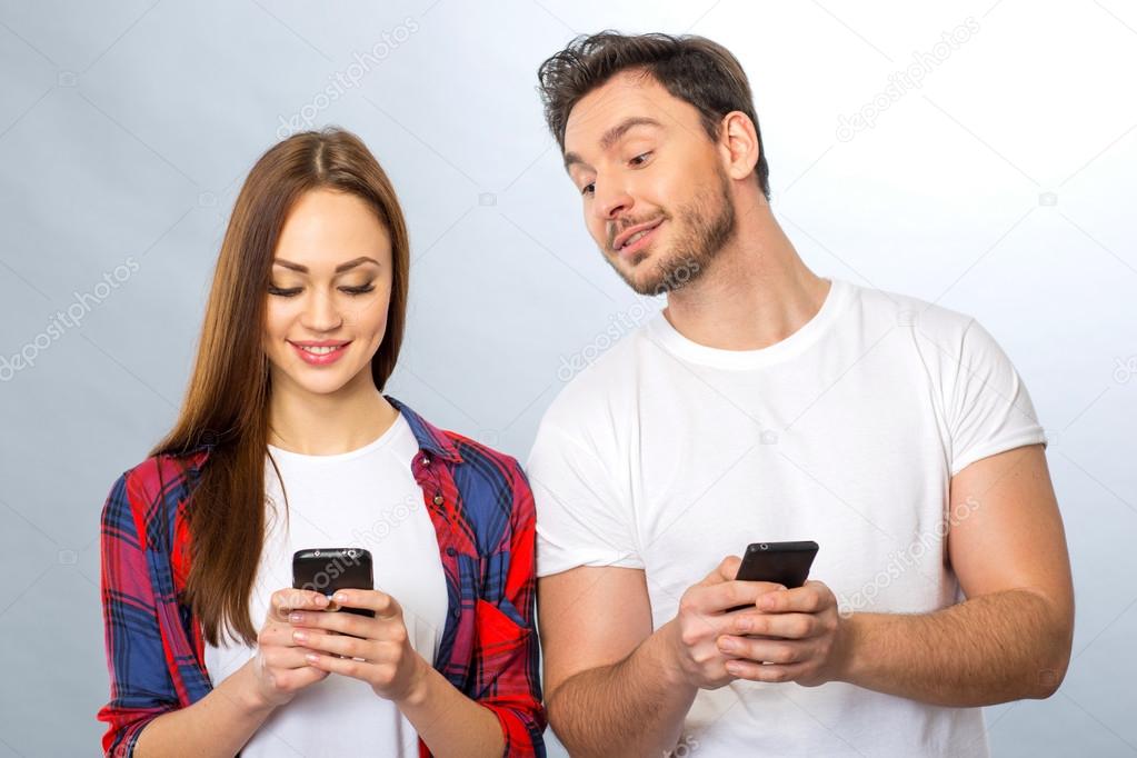 Young couple holding mobile phones