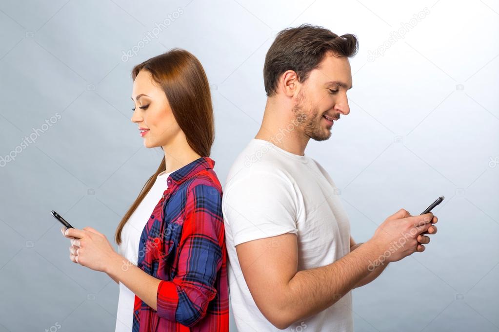 Young couple holding mobile phones