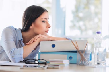 Klasörlerde yaslanmış yorgun iş kadını