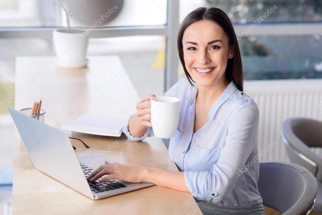 Pleasant business woman sitting at the table